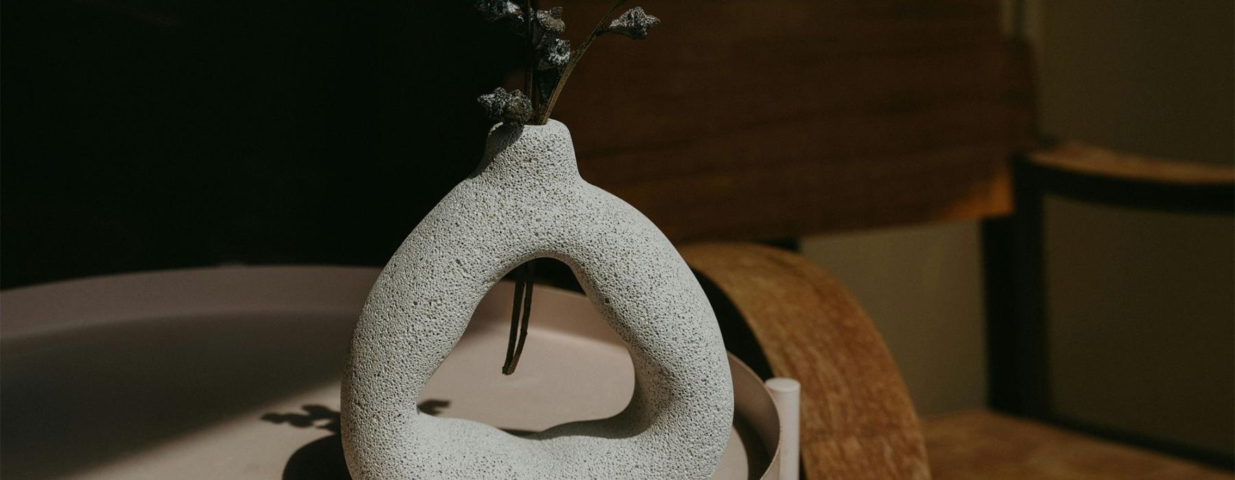 a vase with a plant near a wooden chair